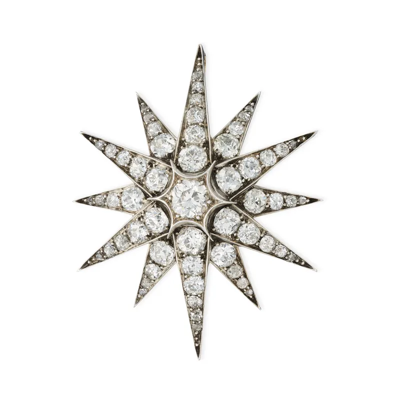 A FINE ANTIQUE DIAMOND STAR BROOCH / PENDANT, 19TH CENTURY in yellow gold and silver, designed as a twelve rayed star, set with a principal old European cut diamond of approximately 0.90 carats, accented by further old and rose cut diamonds, the diam